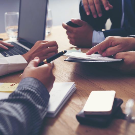 Affärspartners diskuterar dokument och idéer vid mötet